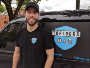 Austin Lafferty, owner of TopLocks, in front of company van with logo